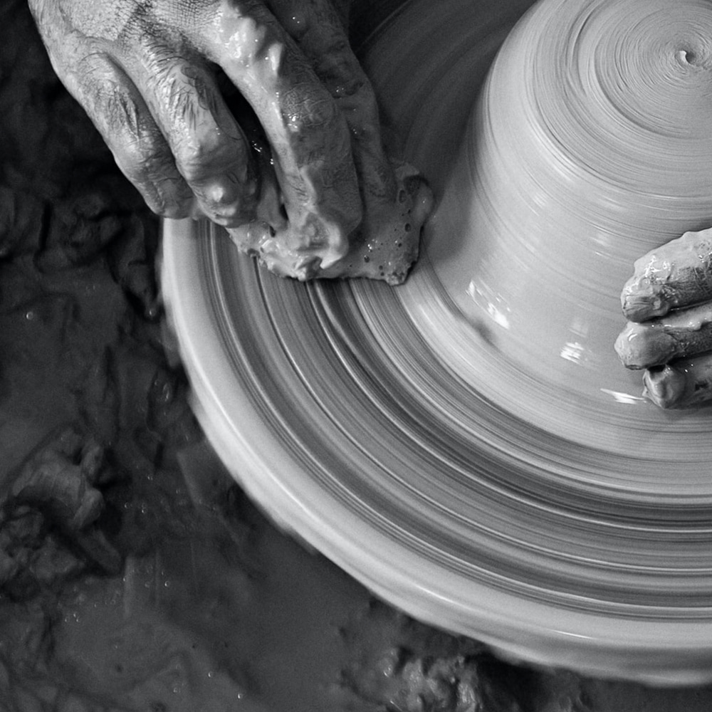 Hands creating pottery on a spinning wheel, symbolizing smooth and flawless skin care results