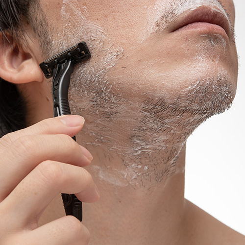 Man shaving beard for clean-shaven look with razor, semi-permanent and safe hair removal